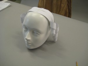 Side view of mannequins head with paper stripes on top of head